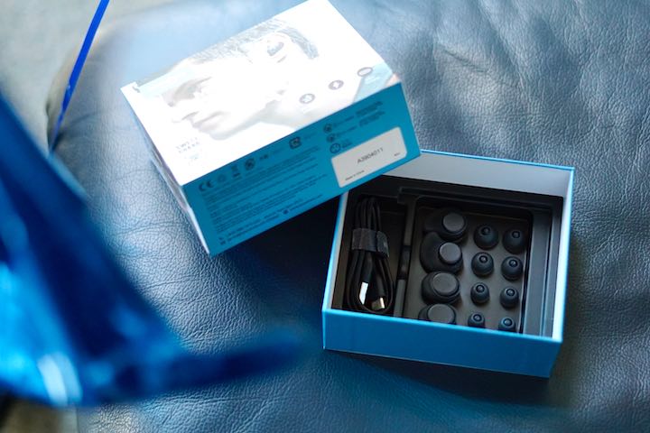 Blaue Soundcore Verpackung liegt auf einem Ledersessel