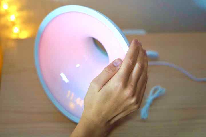 Hand beruehrt Oberseite des Sleep und Wake up Light