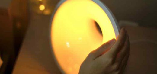 Hand schaltet Philips Lampe mit warmem Licht an 520x245