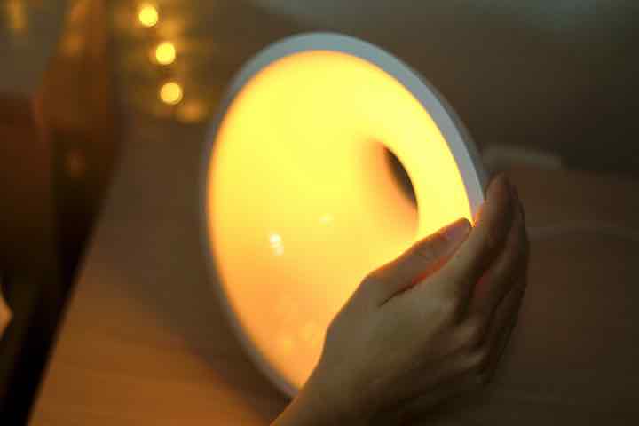 Hand schaltet Philips Lampe mit warmem Licht an