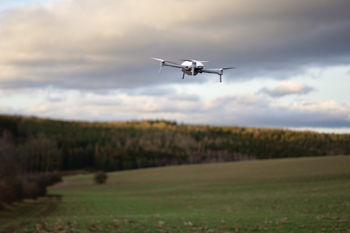 Drohne fliegt %C3%BCber einer Wiese