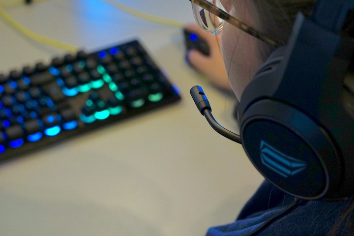 Frau hat ISY IC 6000 Gaming Headset an und sitzt vor einer Tastatur