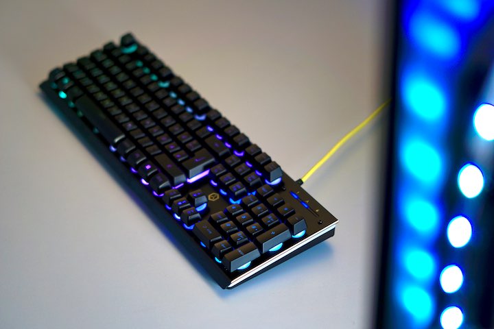 Gaming Tastatur liegt auf Schreibtisch vor leuchtendem LED Streifen