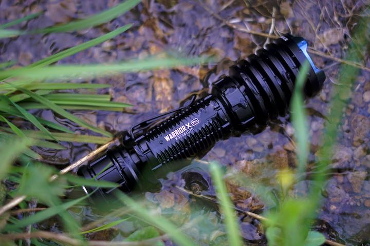 Taschenlampe liegt im Wasser vor Gras
