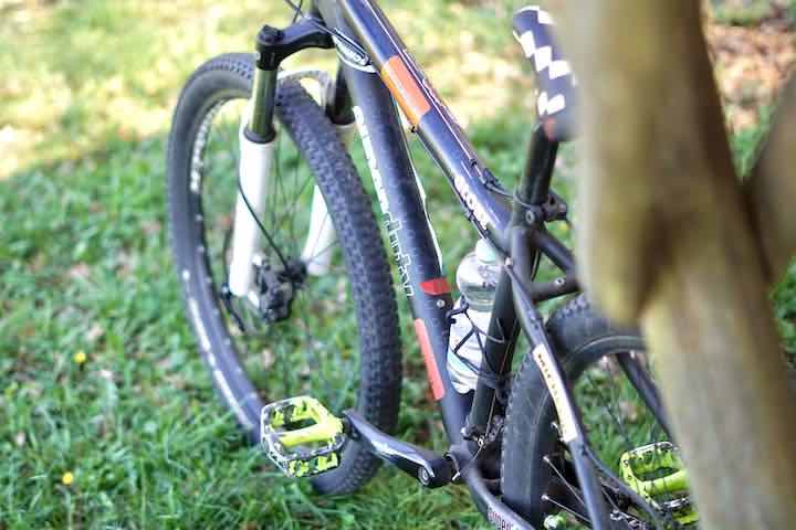 Wasserflasche ist an Fahrrad was auf der Wiese steht befestigt