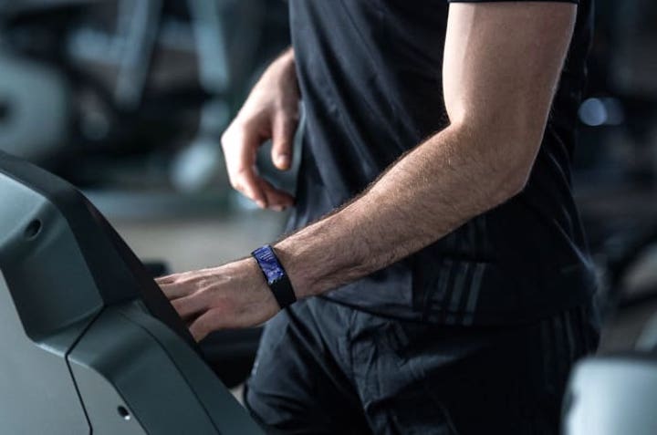 mann im fitnessstudio hat eine smartwatch am arm