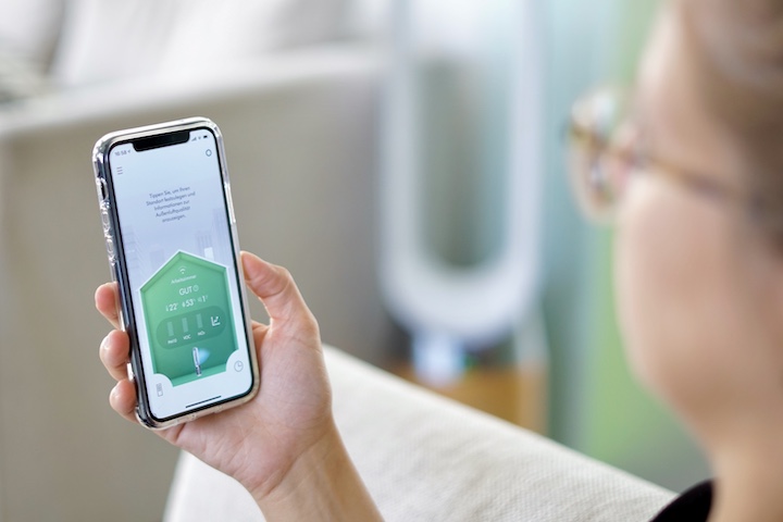 Frau haelt iPhone mit der Dyson App in der Hand