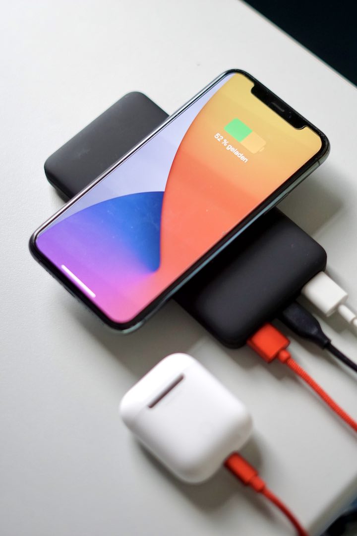 iPhone und AirPods werden auf einer Powerbank geladen