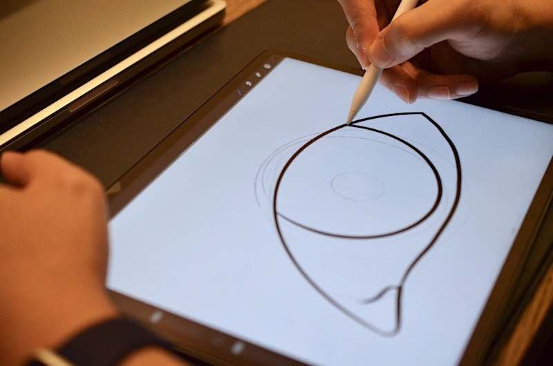 frau zeichnet auf ipad pro mit paperlike