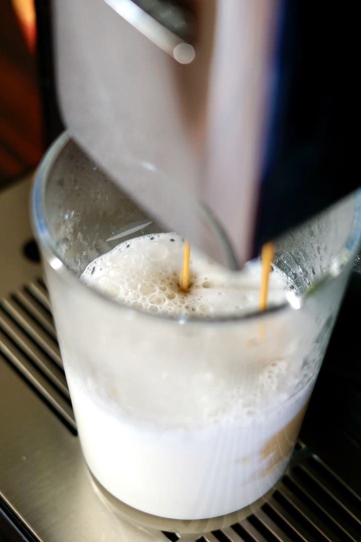 Capuccino wird gerade in ein Glas gefuellt