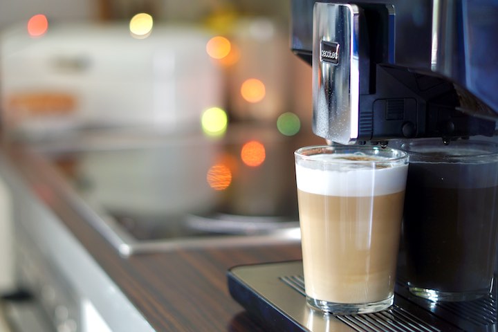 Latte Machiatto auf einer Kaffeemaschine mit Bokeh im Hintergrund