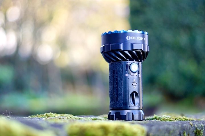 Olight Marauder 2 Taschenlampe steht auf einem Stein