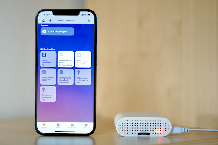 Homekit App auf einem iPhone mit SOMA Connect Box daneben