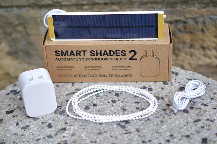 Smart Shades 2 Lieferumfang liegt mit Kabel uns Solarpanel auf einer Steinplatte