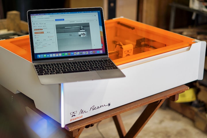 MacBook steht auf einem Lasercutter