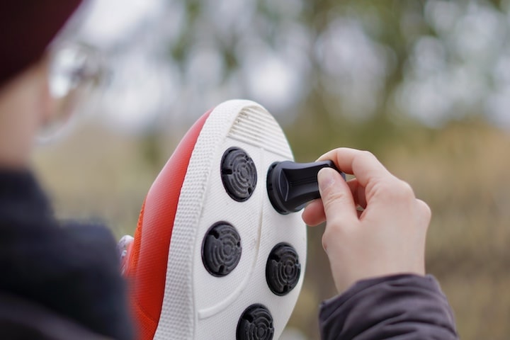 Frau montiert Adapter an einer Schuhsohle