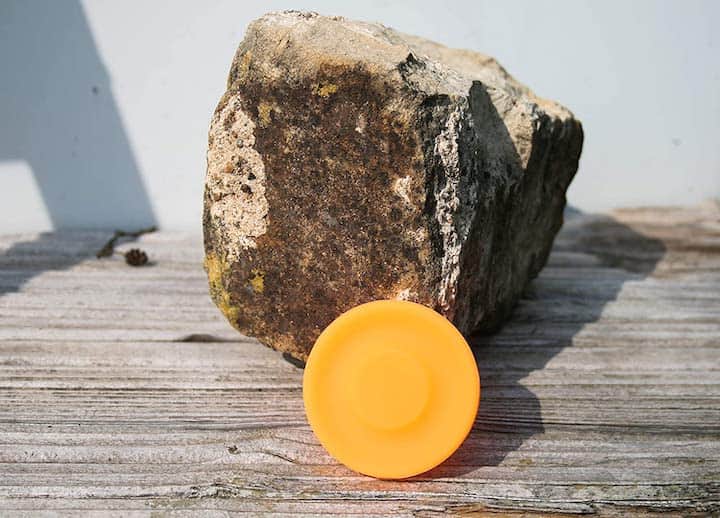 Mini Frisbee in orange liegt vor Stein