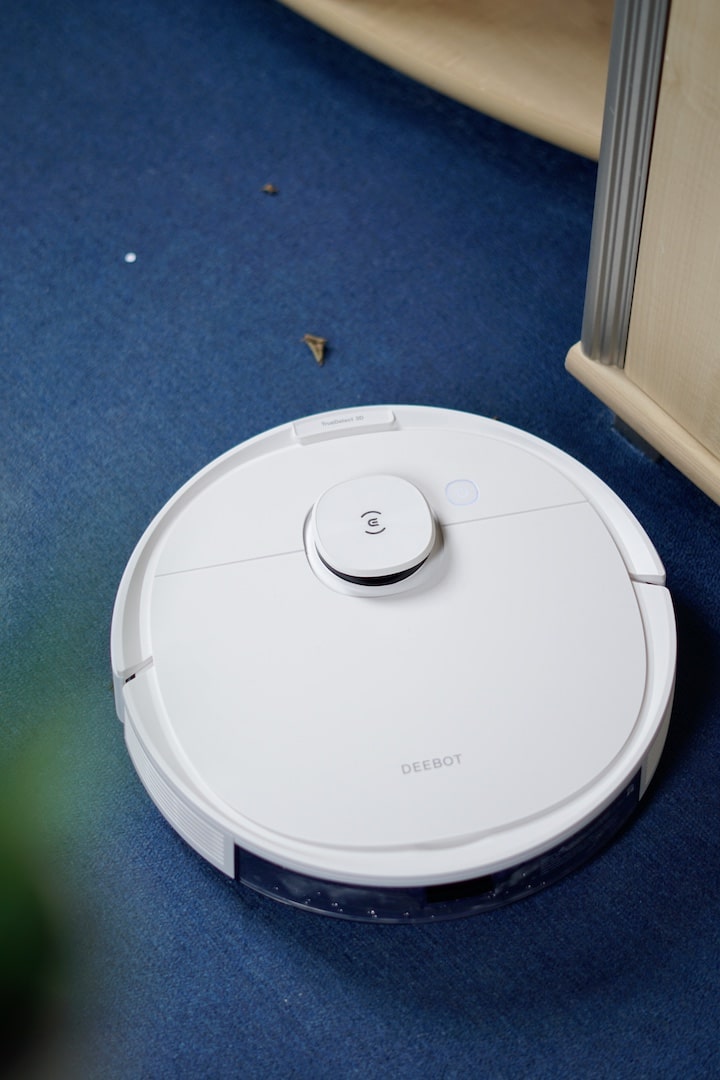 DEEBOT Hybrid Roboter saugt Dreck und Schmutz von einem blauen Teppich
