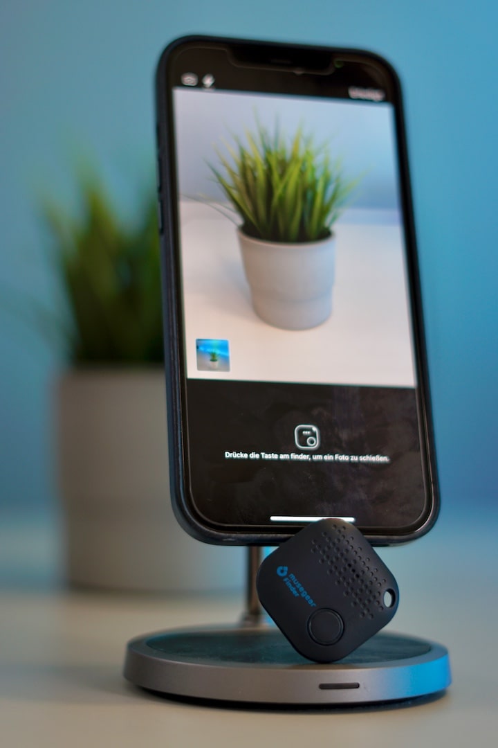 iPhone mit Kamera App und Bluetooth Tracker