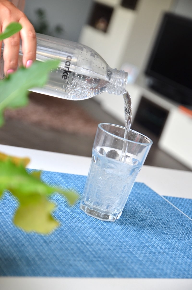 frisch gesprudeltes wasser ins glas schuetten