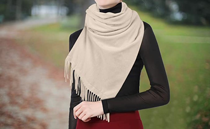 Frau mit selbstwäremden Schal steht in der Natur