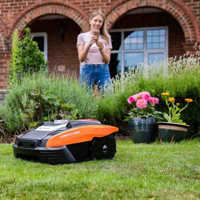 Ein Maehroboter der Yard Force Compact Serie vor einem Haus im Garten