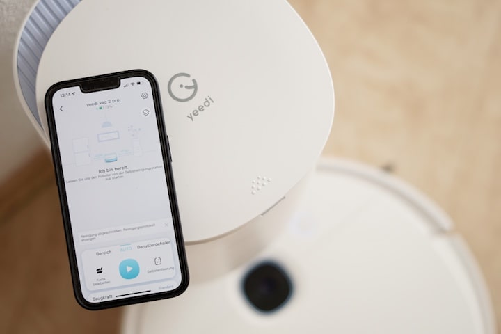 iphone mit yeedi app liegt auf einer vac station