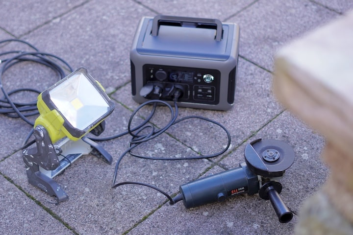 Winkelschleifer und Baustrahler Lampe werden an einer Powerstation betrieben