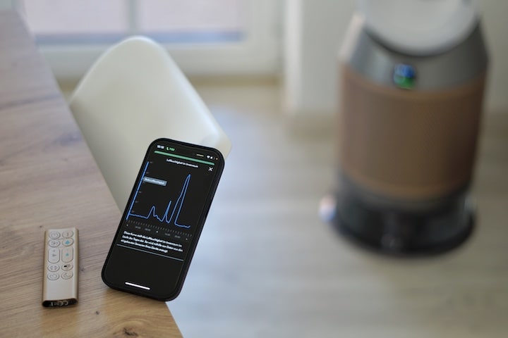 iPhone Handy mit der Dyson App und einer Fernbedienung