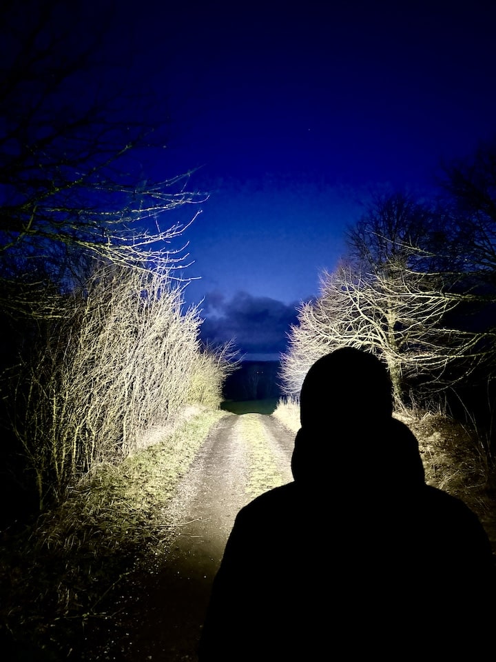 Mann mit Stirnlampe bei Nacht