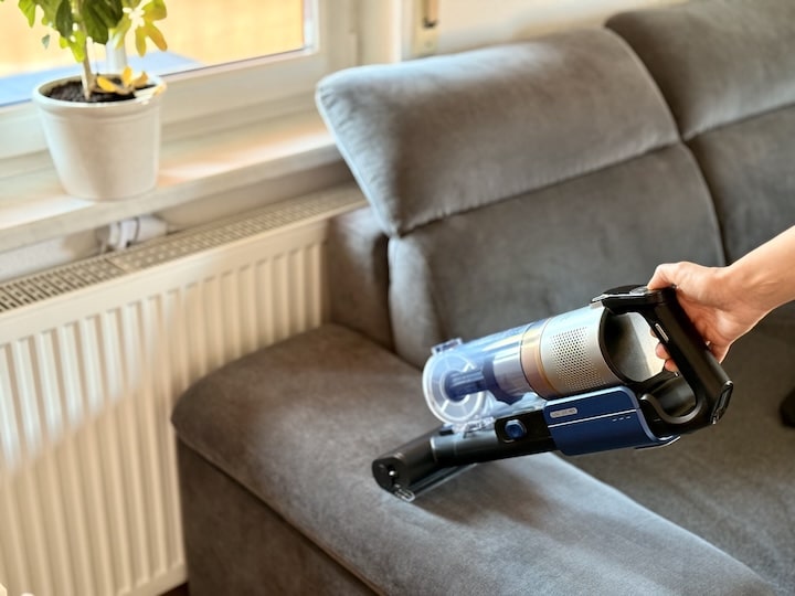 Sofa wird mit kleiner Tierhaar Buerste gerenigt
