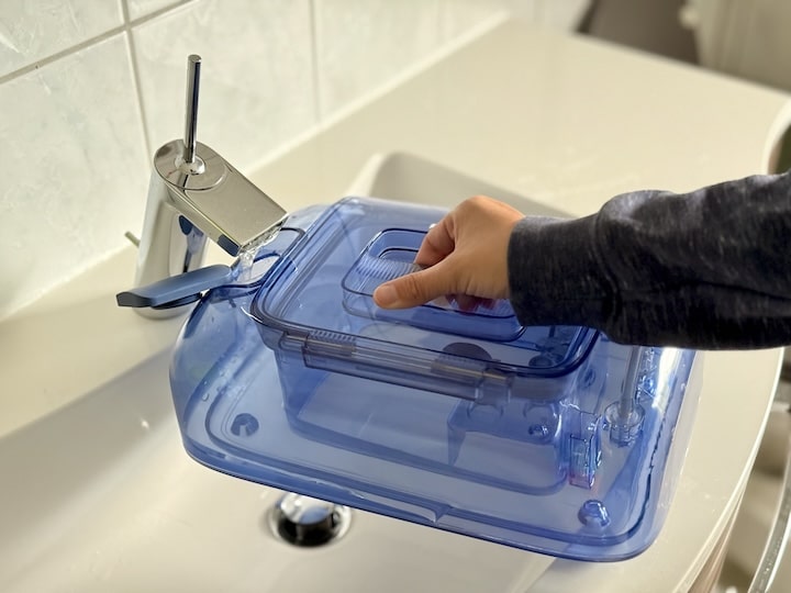 Ecovacs DEEBOT Mini im Test – Klein, smart und gründlich Frau fuellt Wassertank von einem DEEBOT Wischroboter