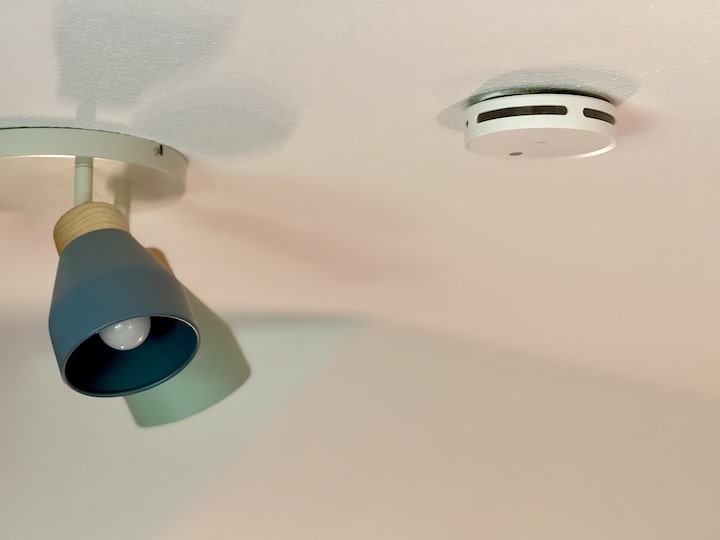 Rauchmelder neben einer Deckenlampe