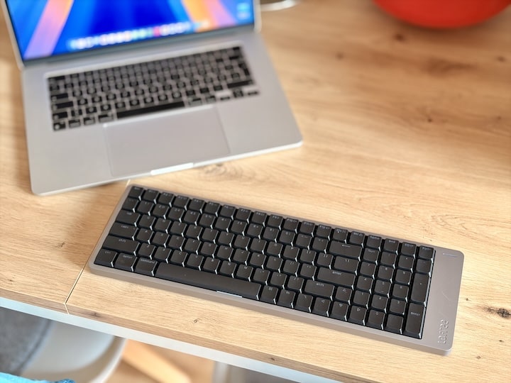 Schwarze mechanische Tastatur vor einem MacBook Air