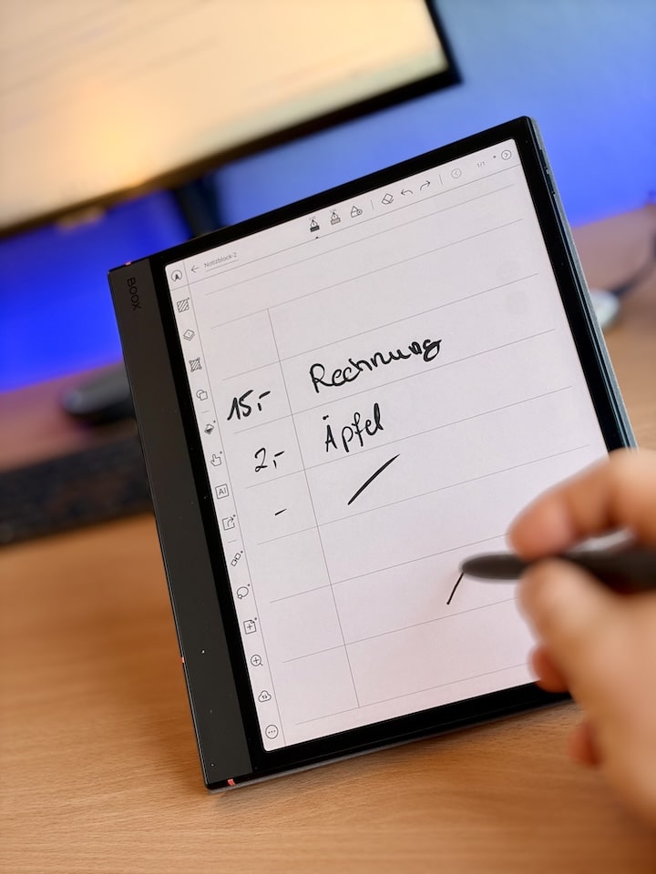 Hand schreibt auf einem Tablet