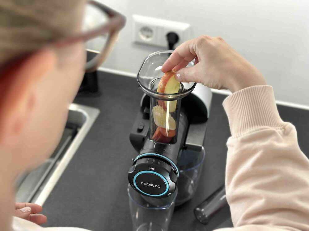 Frau gibt Obst in den Trichter