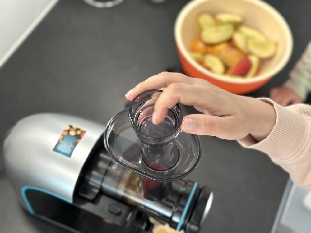 Frau nutzt Stopfer fuer Kaltpresse von Cecotec